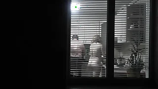 Peeping. Voyeur. Neighbor pervert voyeur give dusk on street looks out window as Vacant sexy neighbor give kitchen prepares act the part of be expeditious for her husband. Vacant give public. Vacant at home. Family&perio
